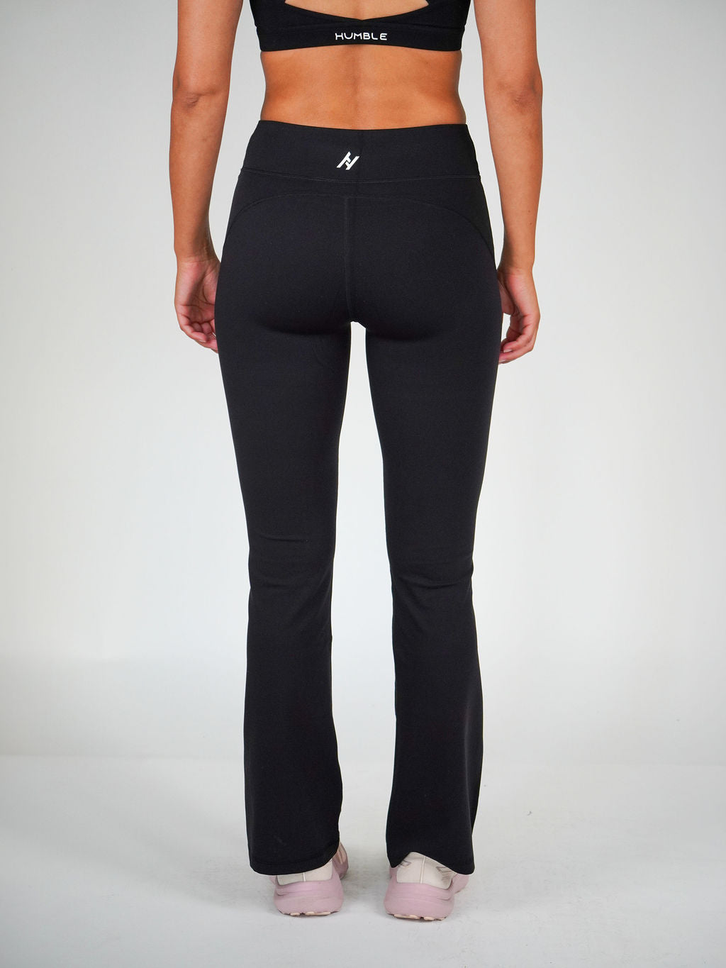 Kvinna i svarta Solid Flare Tights från Humble Athletics