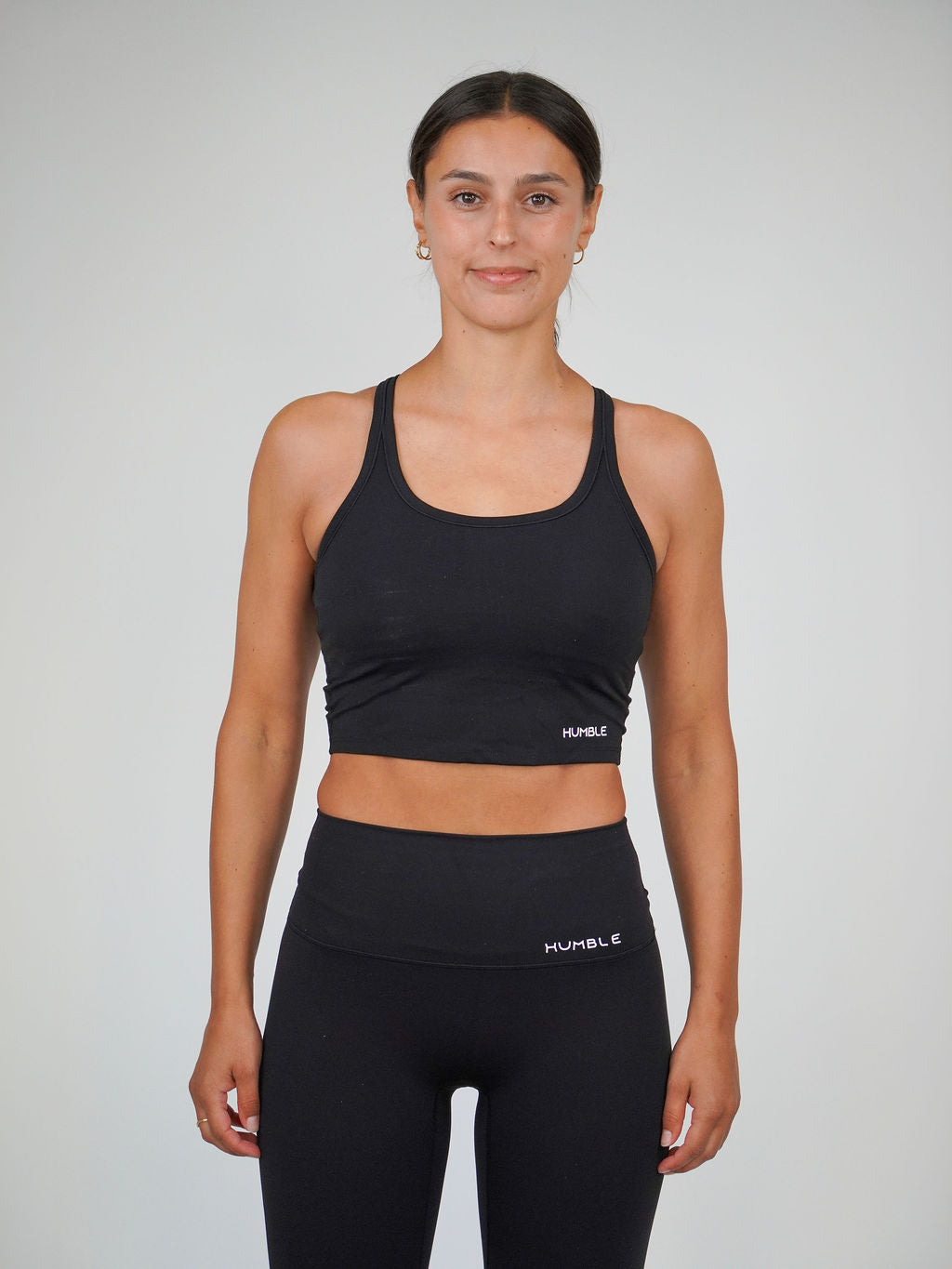 Kvinna i svart Solid Racerback Sports Bra från Humble Athletics