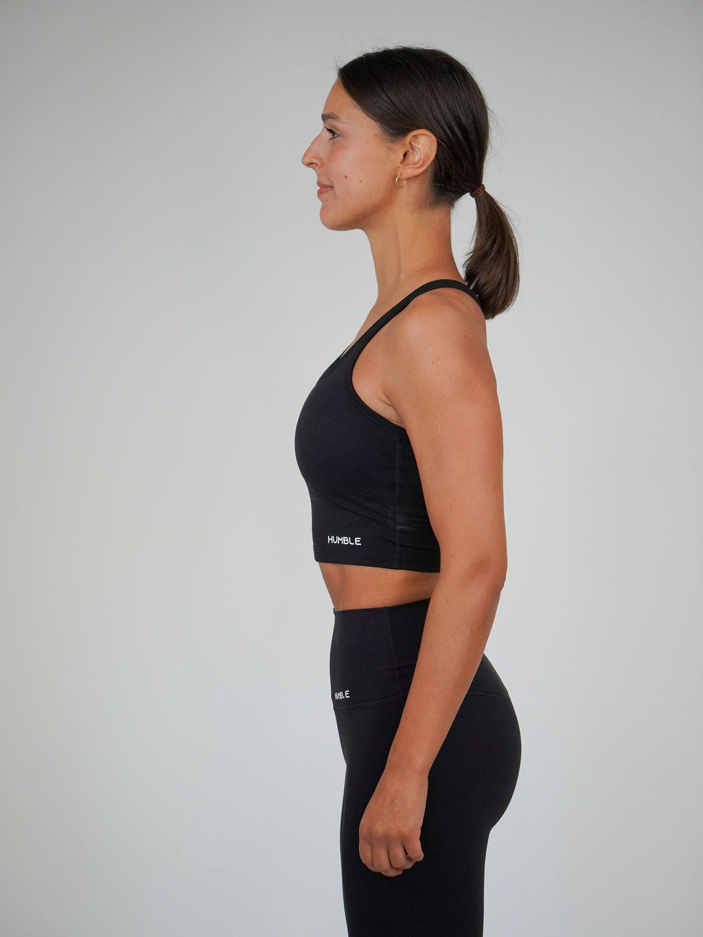 Kvinna i svart Solid Racerback Sports Bra från Humble Athletics
