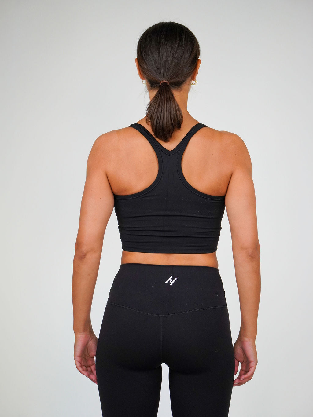 Kvinna i svart Solid Racerback Sports Bra från Humble Athletics